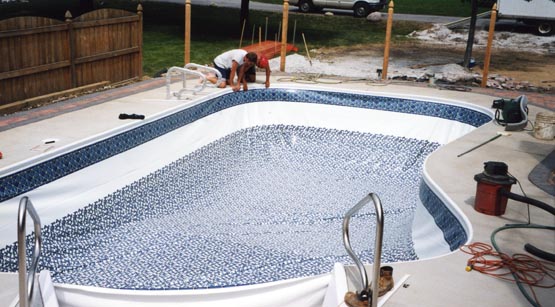 Vinyl liner being installed inside the pool shell