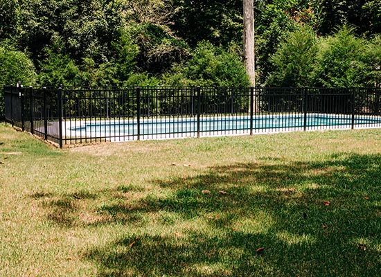 Decorative fence surrounding a backyard pool